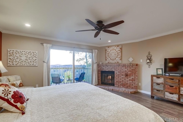 bedroom featuring wood-type flooring, ornamental molding, access to exterior, ceiling fan, and a brick fireplace