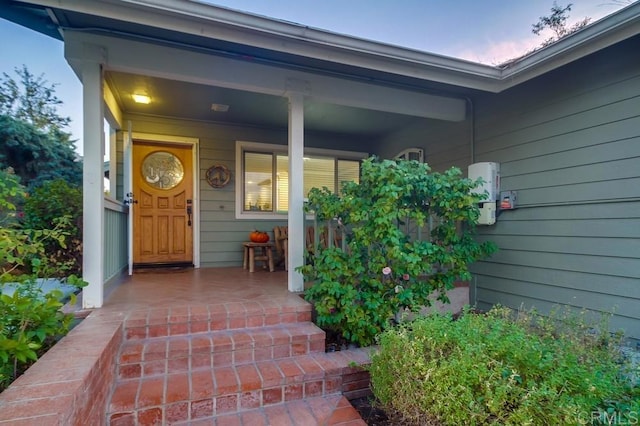 exterior entry at dusk with covered porch