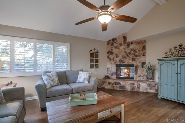 living room with dark hardwood / wood-style floors, ceiling fan, lofted ceiling, and a stone fireplace