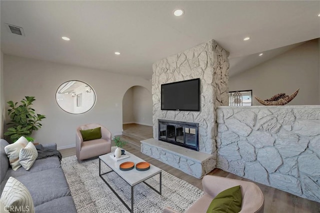 living room with a stone fireplace and light hardwood / wood-style floors