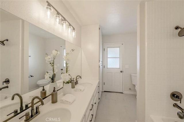 full bathroom featuring tiled shower / bath, vanity, and toilet