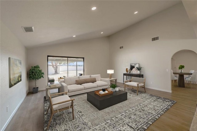 living room featuring high vaulted ceiling and light hardwood / wood-style floors