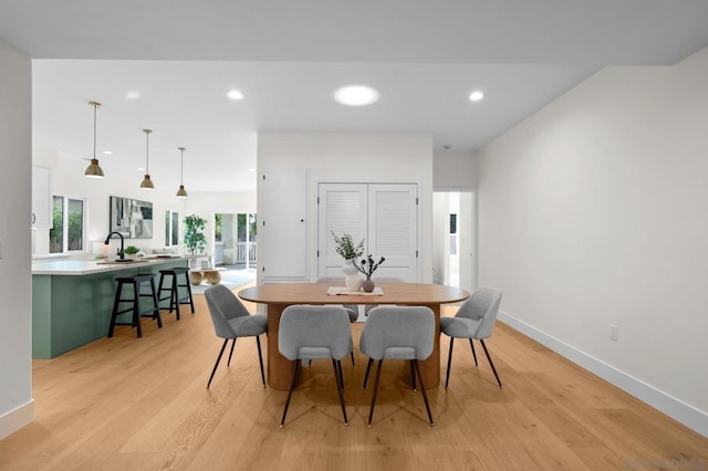 dining room featuring sink and light hardwood / wood-style flooring