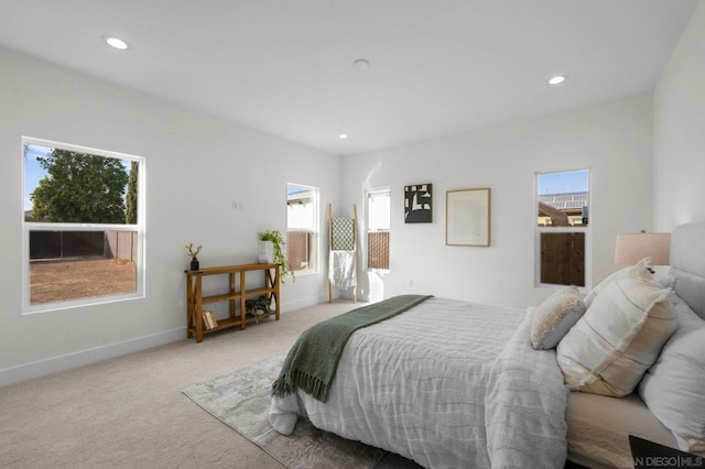 bedroom with multiple windows and light colored carpet