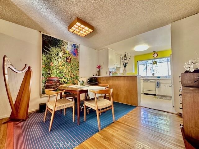 dining room featuring hardwood / wood-style flooring and a textured ceiling