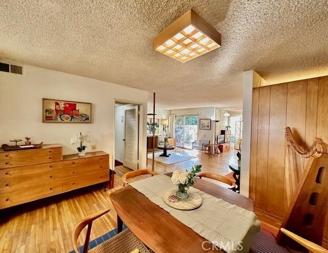 dining area featuring hardwood / wood-style floors and a textured ceiling