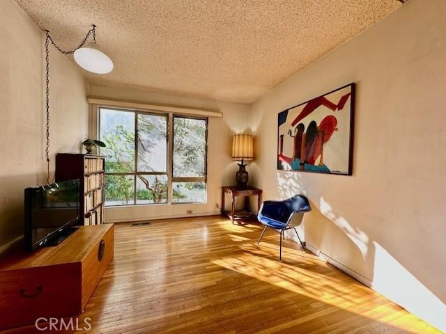 sitting room featuring hardwood / wood-style flooring and a textured ceiling