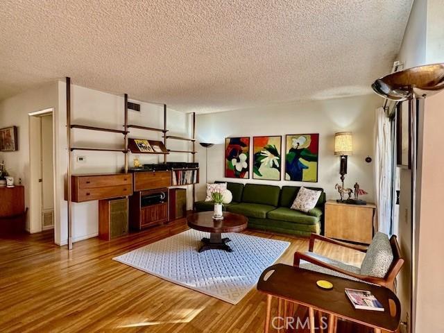 living room featuring hardwood / wood-style floors and a textured ceiling