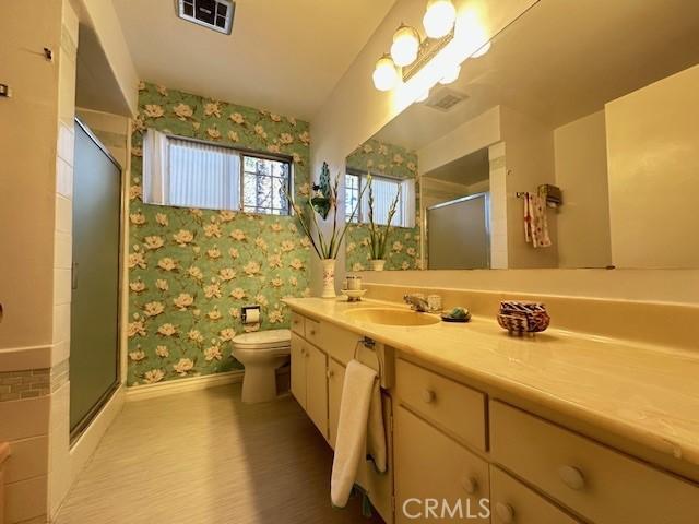 bathroom featuring vanity, toilet, and walk in shower