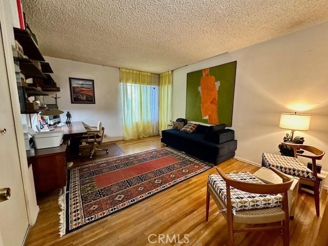 living area featuring hardwood / wood-style floors and a textured ceiling