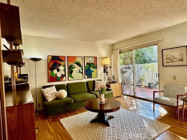 living room with wood-type flooring and a textured ceiling