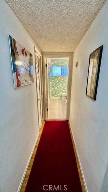 hall with hardwood / wood-style flooring and a textured ceiling