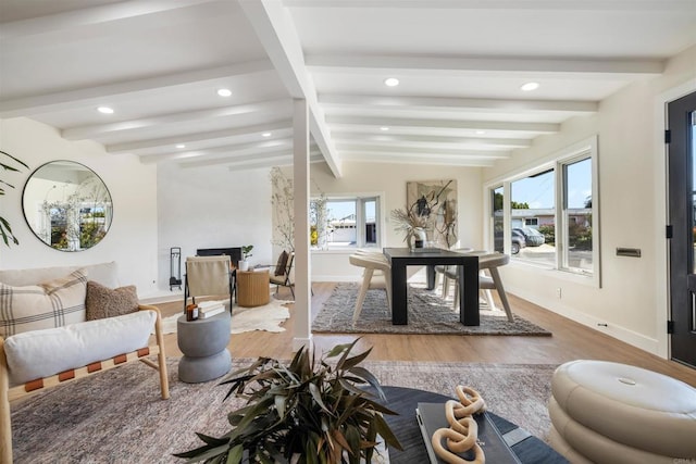 interior space with lofted ceiling with beams, wood-type flooring, and plenty of natural light