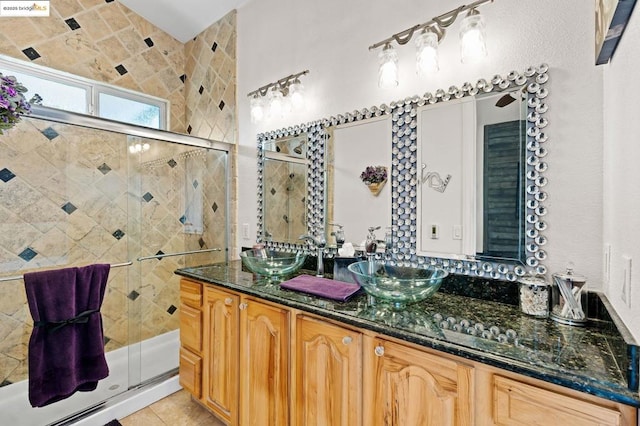 bathroom with walk in shower, tile patterned floors, and vanity