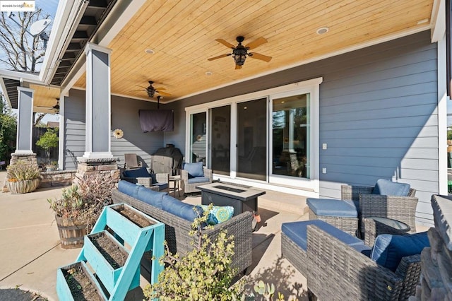 view of patio / terrace with an outdoor living space with a fire pit and ceiling fan