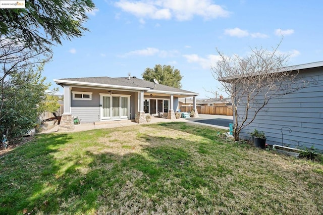 back of property with a patio, ceiling fan, and a lawn