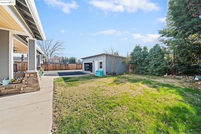 view of yard featuring a garage, an outbuilding, and a patio