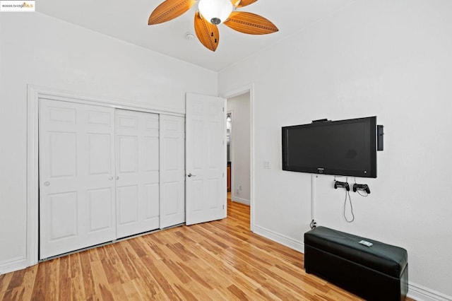 unfurnished bedroom featuring ceiling fan, light hardwood / wood-style floors, and a closet