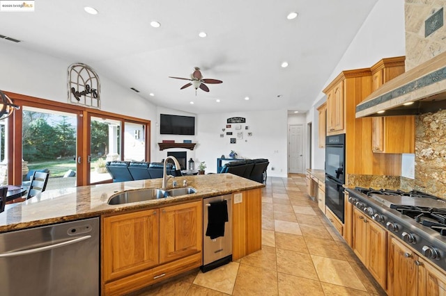 kitchen featuring lofted ceiling, sink, a center island with sink, appliances with stainless steel finishes, and custom range hood