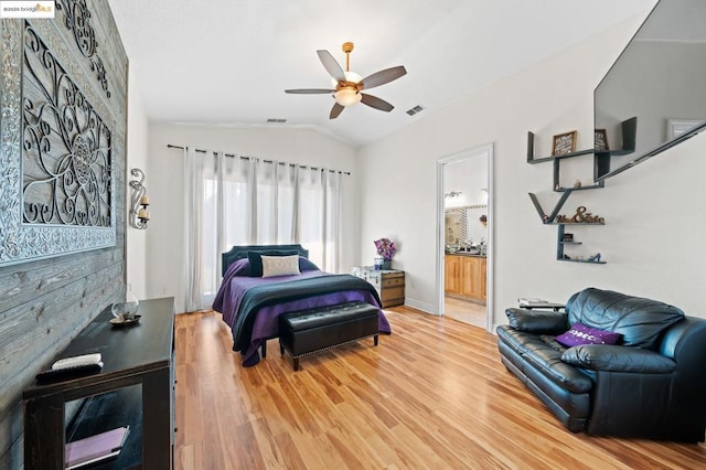 bedroom featuring hardwood / wood-style flooring, ceiling fan, lofted ceiling, and ensuite bathroom