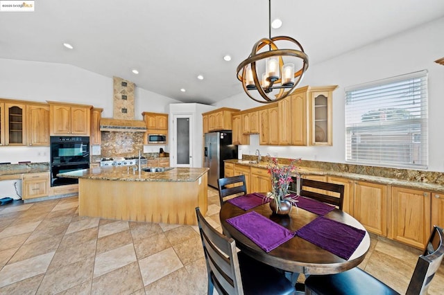 kitchen with pendant lighting, premium range hood, appliances with stainless steel finishes, light stone counters, and a center island with sink