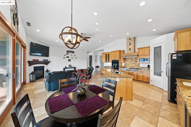 tiled dining space with vaulted ceiling, sink, and a notable chandelier