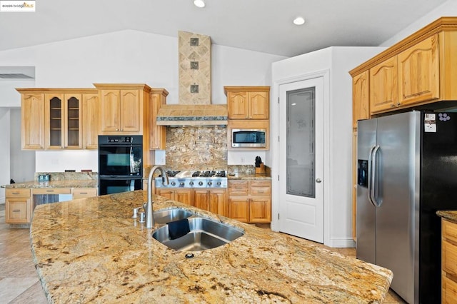 kitchen featuring lofted ceiling, sink, stainless steel appliances, light stone countertops, and decorative backsplash