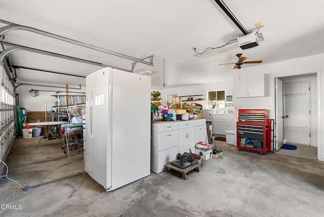 garage featuring a garage door opener, white refrigerator, ceiling fan, and a workshop area