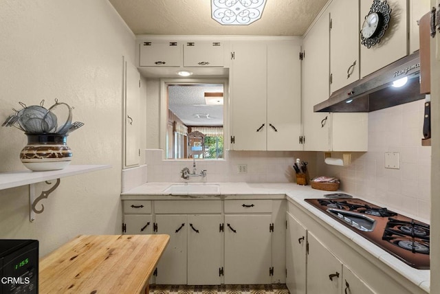 kitchen with sink, white cabinets, backsplash, gas cooktop, and a textured ceiling