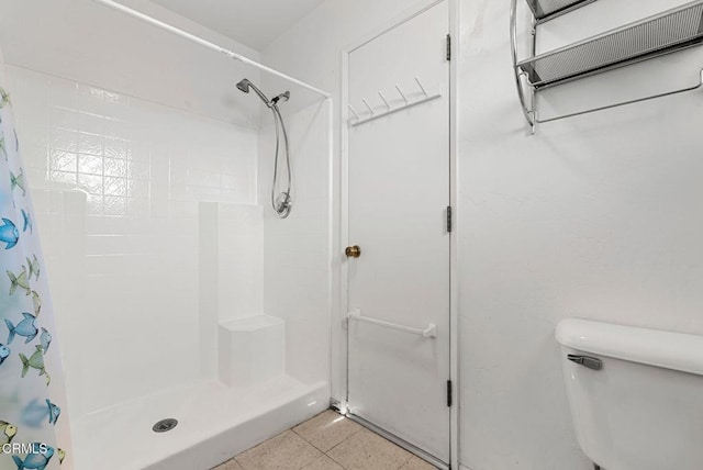 bathroom featuring tile patterned flooring, a shower with curtain, and toilet