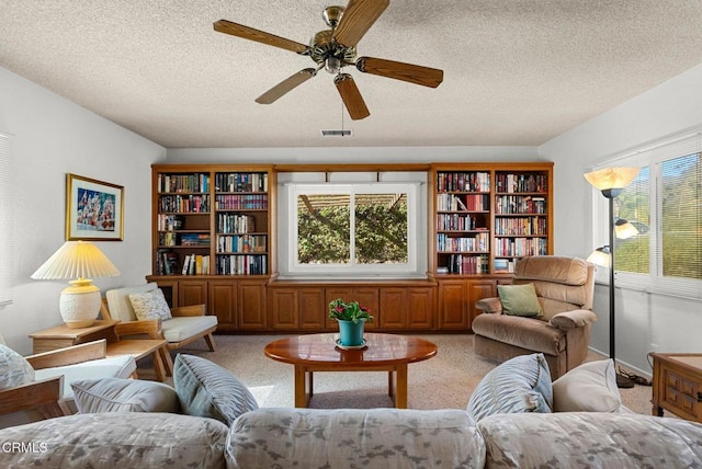 living area with light colored carpet, plenty of natural light, and visible vents