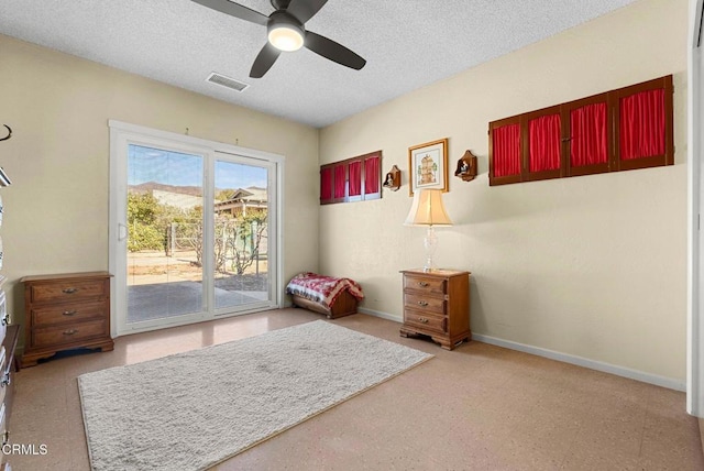 interior space with baseboards, a ceiling fan, a textured ceiling, and visible vents