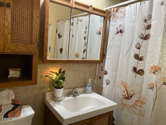 bathroom with vanity, a shower with shower curtain, and toilet
