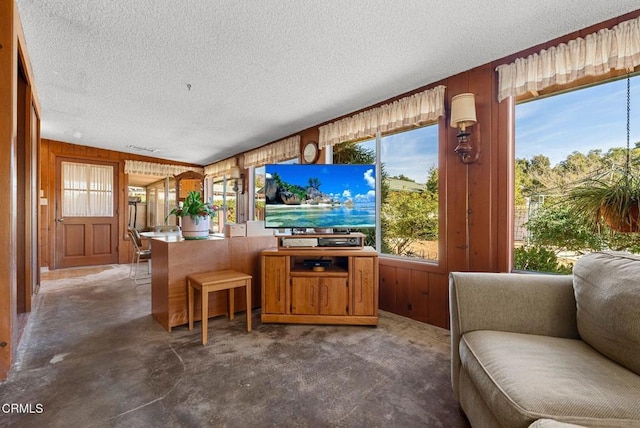living room with a textured ceiling and wooden walls