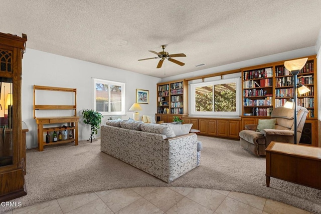 living room with a textured ceiling, ceiling fan, light carpet, and plenty of natural light