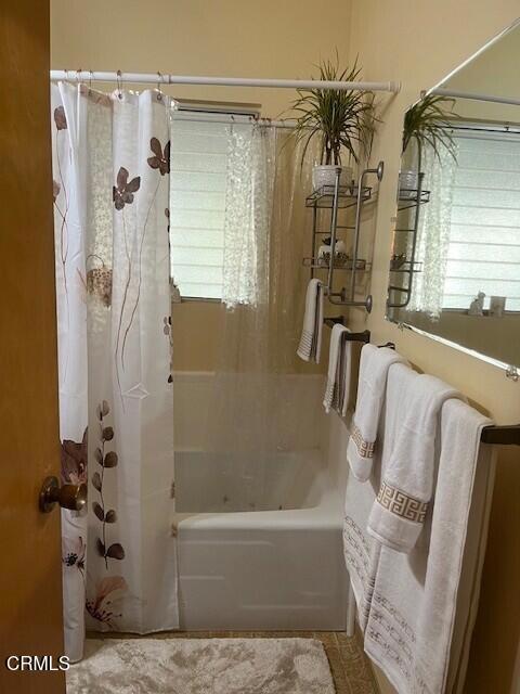 bathroom with shower / bath combination with curtain
