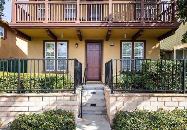 view of exterior entry with a balcony