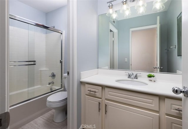 full bathroom with vanity, combined bath / shower with glass door, and toilet