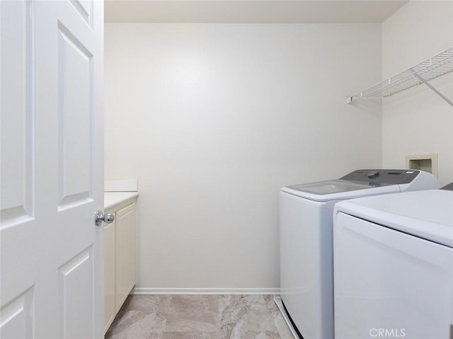 laundry room with separate washer and dryer and cabinets