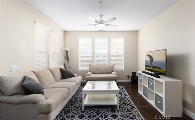 living room featuring dark wood-type flooring and ceiling fan