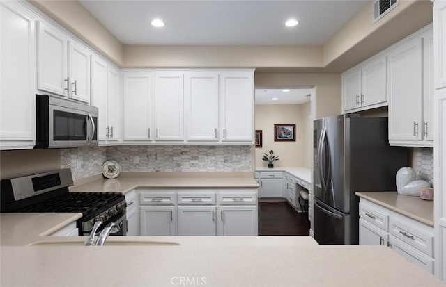 kitchen with white cabinetry, appliances with stainless steel finishes, sink, and backsplash