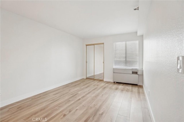 unfurnished bedroom with light hardwood / wood-style floors and a closet