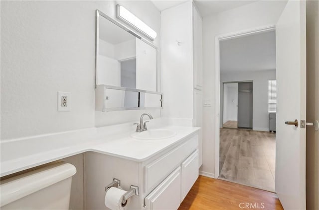 bathroom featuring wood-type flooring, toilet, and vanity