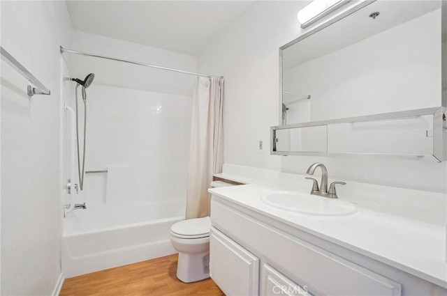 full bathroom featuring wood-type flooring, vanity, shower / bath combo with shower curtain, and toilet