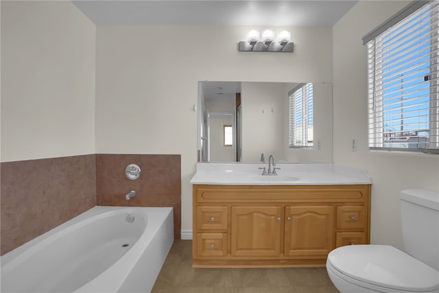 bathroom featuring vanity, a bathing tub, tile patterned floors, and toilet