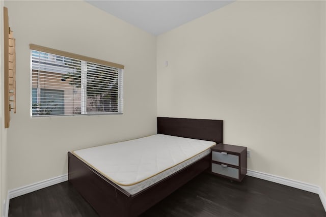 bedroom with dark wood-type flooring