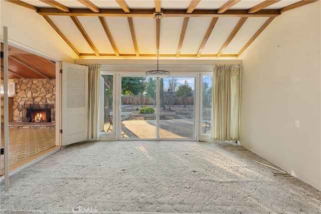 unfurnished living room with beam ceiling, a fireplace, and high vaulted ceiling