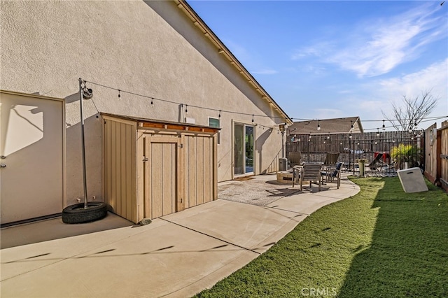 rear view of house with a storage shed, a patio area, and a lawn