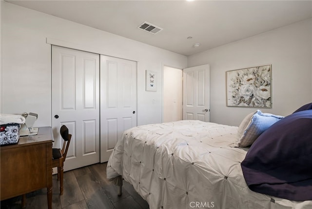 bedroom with dark hardwood / wood-style flooring and a closet