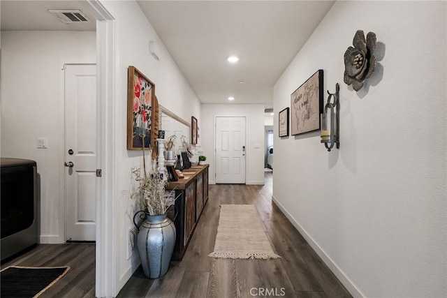 corridor with dark hardwood / wood-style flooring and washer / clothes dryer